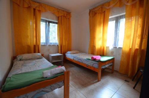 a bedroom with two beds and two windows at Aeropuerto Ezeiza 10 minutos de Aeropuerto in Monte Grande