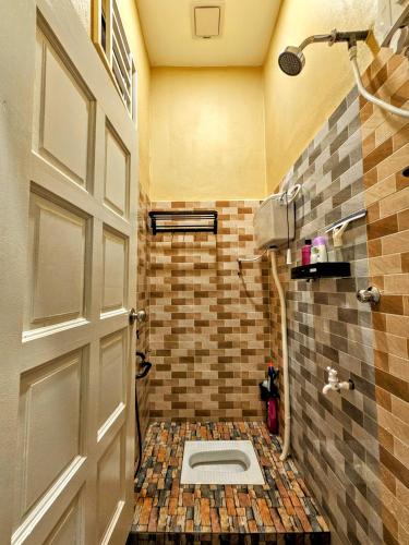 a bathroom with a toilet on a tiled floor at Homestay Rumah Tengok Jelawat Bachok in Bachok