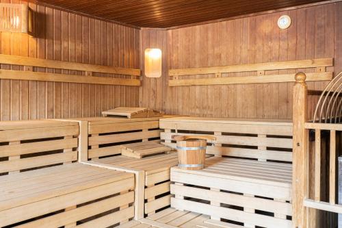 a sauna with wooden seats and a bucket in it at Ferienclub Bellevue am See in Walchsee