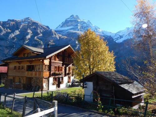 a house with a mountain in the background at Olle and Maria's B&B- apartment in Gimmelwald