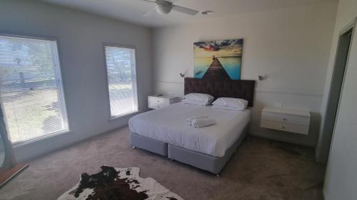 een slaapkamer met een bed en 2 ramen bij 505 CONROD STRAIGHT MOUNT PANORAMA in Bathurst