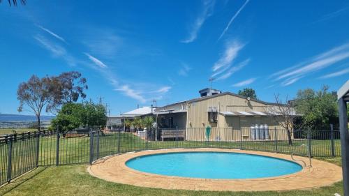 a pool in front of a house with a fence at 505a CONROD STRAIGHT MOUNT PANORAMA in Bathurst