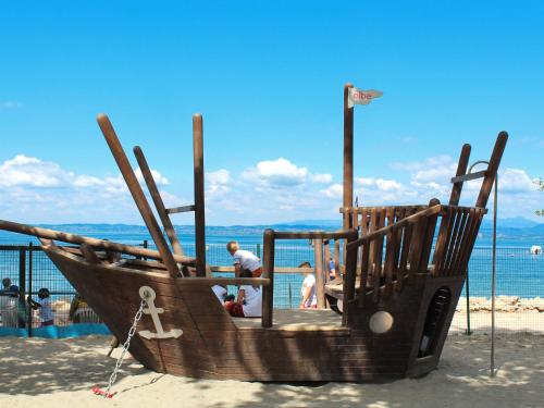a wooden boat on the beach with people in it at Holiday Home Cisano & San Vito-5 by Interhome in Calmasino