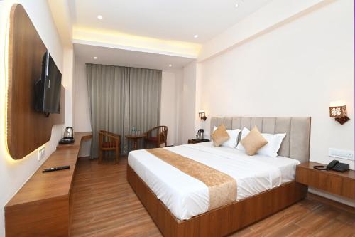 Habitación de hotel con cama y TV en Hotel Blue Sapphire en Kota