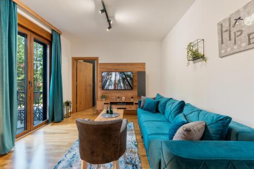 a living room with a blue couch and a table at Apartman Zelenbor 4 Vila Zlatibor Luxury&Spa in Zlatibor