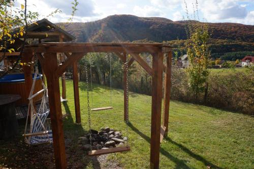 a swing in a yard with a pile of rocks at Natura Chalets in Praid