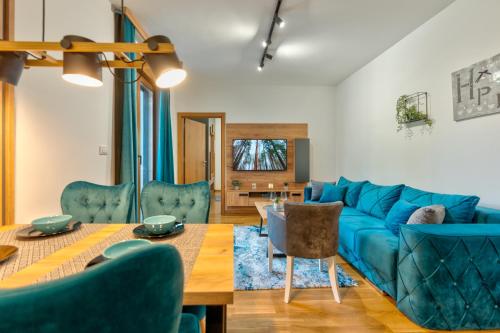 a living room with a blue couch and a table at Apartman Zelenbor 4 Vila Zlatibor Luxury&Spa in Zlatibor