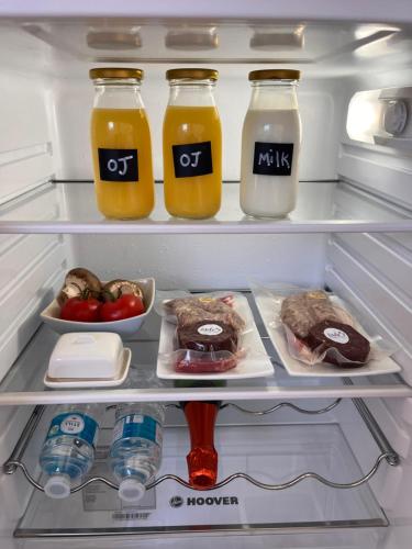 an open refrigerator filled with drinks and food at The Honeysuckle Coop in Grantham