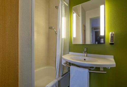 アングラン・シュル・メールにあるB&B HOTEL La Rochelle Angoulinsのバスルーム(シンク、鏡、バスタブ付)