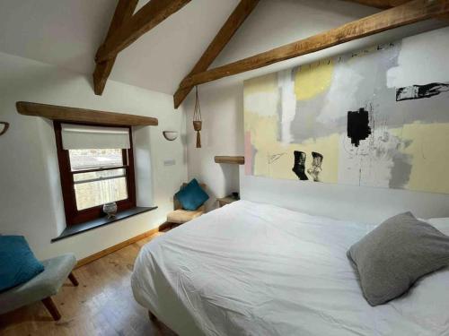 a bedroom with a white bed and a window at 9A Viaduct Cottage - the cosiest bolthole in the SW! in Hayle