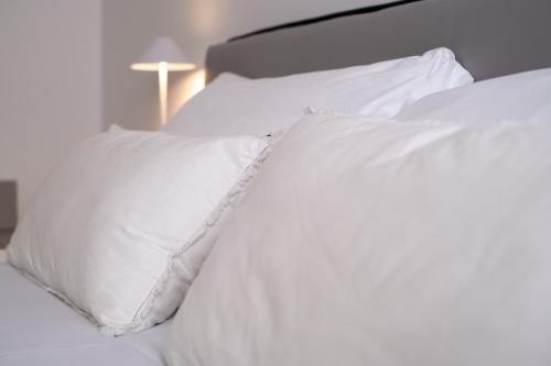 a white bed with white sheets and pillows at Veroniamo in Verona