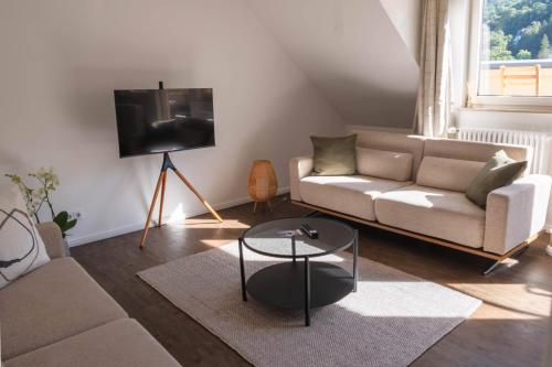 a living room with a couch and a tv at Apartment am Kurpark mit traumhafter Terrasse in Bad Ems