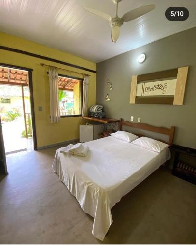 a bedroom with a large white bed in a room at Pousada Embaubas in Serra do Cipo