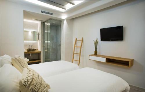 - une chambre avec 2 lits et une télévision murale dans l'établissement Luxury Mykonos Villa - Stunning Seaviews - 4 Bedrooms - Jacuzzi - Agia Sofia Villa, à Tourlos