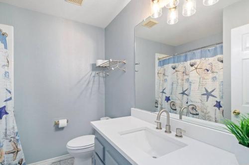 Un baño con lavabo, inodoro y espejo. en Hot Tub! 4BR 3BA Modern, newly remodeled, 16 ppl, en McKinney