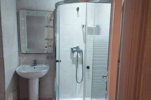 uma casa de banho com um lavatório e um chuveiro com um lavatório. em Ali's App Arts em Kenitra