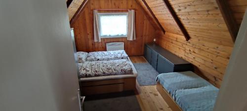 a small room with two beds and a window at Chatky u potoka, chatička č. 1 in Olešnice v Orlických horách