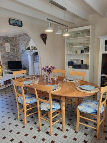 une salle à manger avec une table et des chaises en bois dans l'établissement Gîte La rose des vents., à Pirou