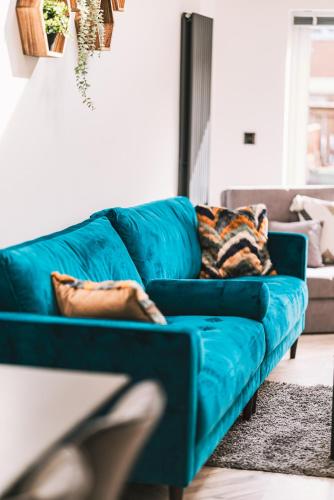 a blue couch in a living room at Luxurious 3 Bed Home, Free Parking in Manchester