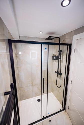 a shower with a glass door in a bathroom at Luxurious 3 Bed Home, Free Parking in Manchester