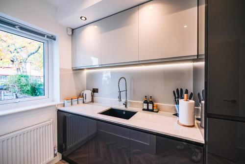 eine Küche mit einem Waschbecken und einem Fenster in der Unterkunft Luxurious 3 Bed Home, Free Parking in Manchester