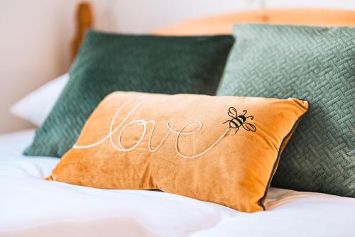 a pillow with the word love on it sitting on a bed at Luxurious 3 Bed Home, Free Parking in Manchester