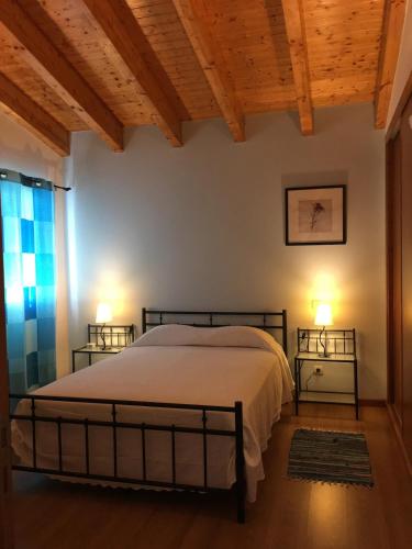 a bedroom with a bed with two night stands next to a window at Madrugada in Évora