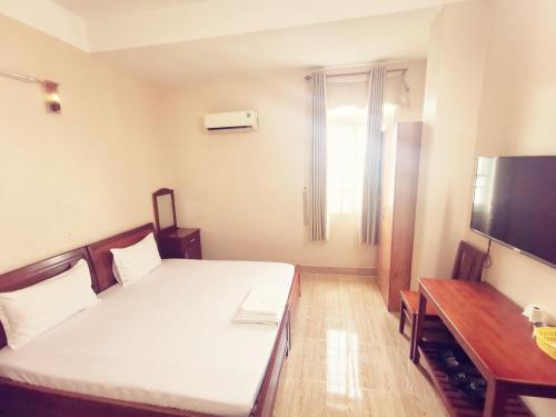 a hotel room with a bed and a television at KHÁCH SẠN CÚC PHƯƠNG (CÚC PHƯƠNG HOTEL) in Dĩ An