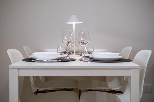 a white table with wine glasses and plates on it at Veroniamo in Verona