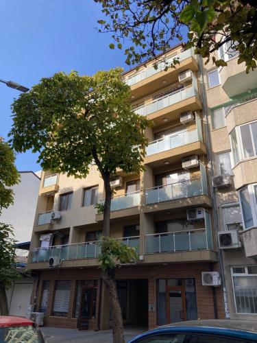 an apartment building with a tree in front of it at Le petit escape in Varna City