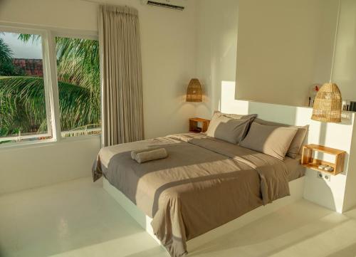 1 dormitorio con cama y ventana grande en The Peak Surf House, en Huu