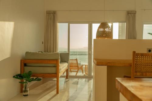 a living room with a couch and a view of the ocean at The Peak Surf House in Huu