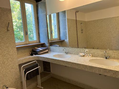 ein Badezimmer mit zwei Waschbecken und einem großen Spiegel in der Unterkunft Auberge du désert 