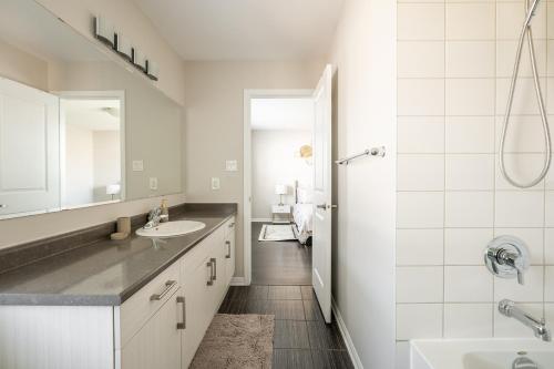 a white bathroom with a sink and a shower at GLOBALSTAY Modern 3 Bedroom House in Brampton in Brampton