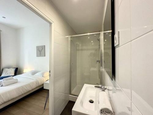 une salle de bain avec un lavabo et une douche et un lit dans l'établissement Cosy appart - lyon 6 - Gare Partdieu - Lafayette 1, à Lyon