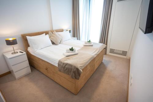 a bedroom with a bed with white sheets and a window at Beograd na vodi - Belgrade Waterfront Riverside in Belgrade