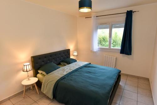 Un dormitorio con una cama grande y una ventana en BEAU T3 SPACIEUX PROCHE CENTRE ViLLE, en Brive-la-Gaillarde