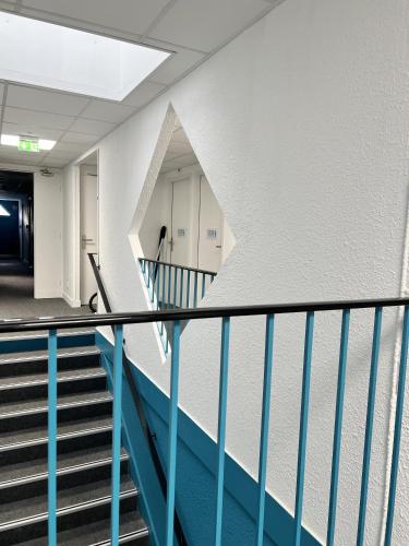 an empty hallway with stairs in a building at Kyriad Direct Moulins Sud - Yzeure in Moulins
