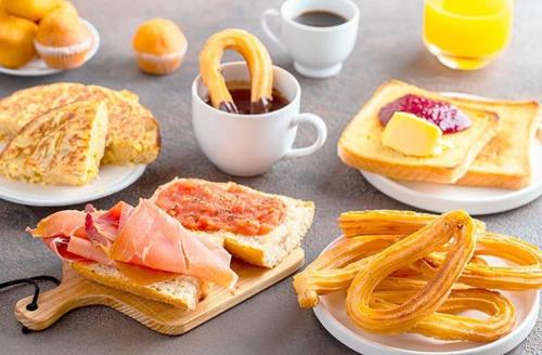 a table with plates of breakfast foods and a cup of coffee at Apartamento Retro in Sagunto