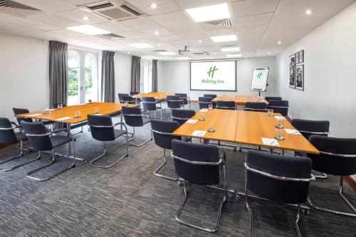 a conference room with wooden tables and chairs at Holiday Inn Gloucester - Cheltenham by IHG in Gloucester