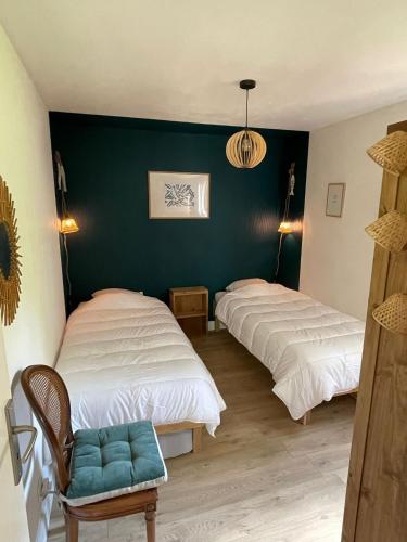 - 2 lits dans une chambre dotée d'un mur vert dans l'établissement Cabane C60, à Lège-Cap-Ferret