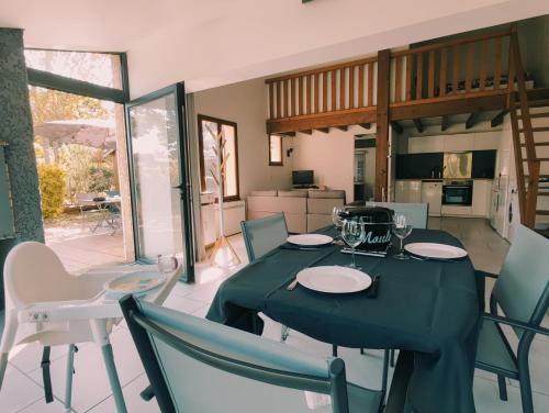 une salle à manger avec une table et des chaises dans l'établissement Maison Times, à Arès