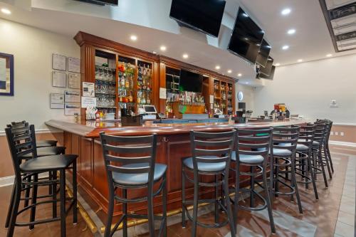 a bar with a row of stools in a restaurant at Clarion Hotel & Suites BWI Airport North in Baltimore