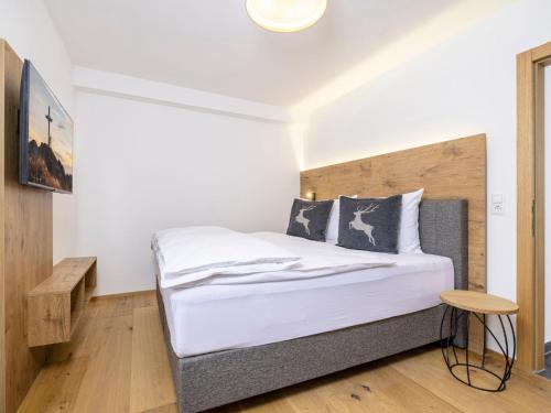 una camera da letto con un letto con testiera in legno di Apartment Suprior Bergblick 06 by Interhome a Söll