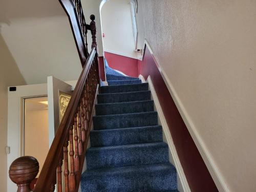 a flight of stairs in a building with blue carpet at Victoria Guest House in Stoke on Trent