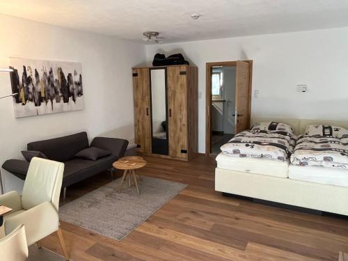 a bedroom with a bed and a couch and a table at Apartment Am Birkenhain-2 by Interhome in Seefeld in Tirol