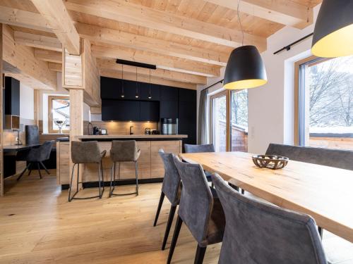 a kitchen and dining room with a wooden table and chairs at Apartment Penthouse large Bergblick 19 by Interhome in Söll
