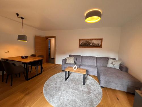 a living room with a couch and a table at Apartment Comfort Bergblick 04 by Interhome in Söll