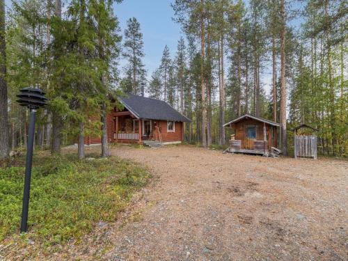 a cabin in the woods next to a dirt road at Holiday Home Kuukkelin tupa 1 by Interhome in Pyhätunturi