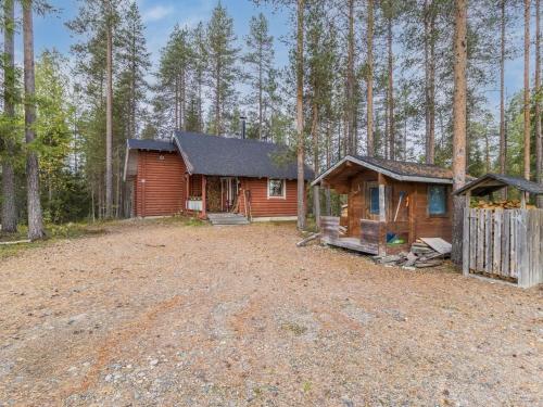 a cabin in the woods next to a dirt road at Holiday Home Kuukkelin tupa 1 by Interhome in Pyhätunturi